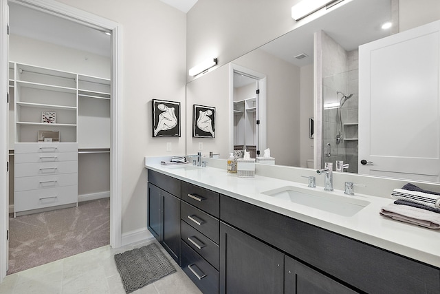 bathroom featuring tile patterned flooring, vanity, and walk in shower