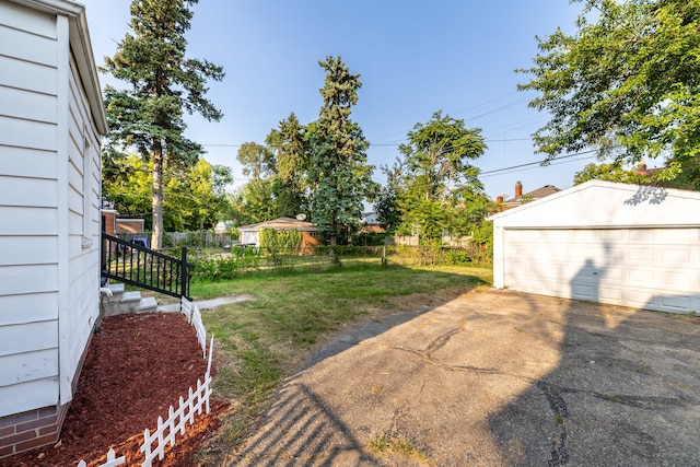 view of yard with a garage and an outbuilding