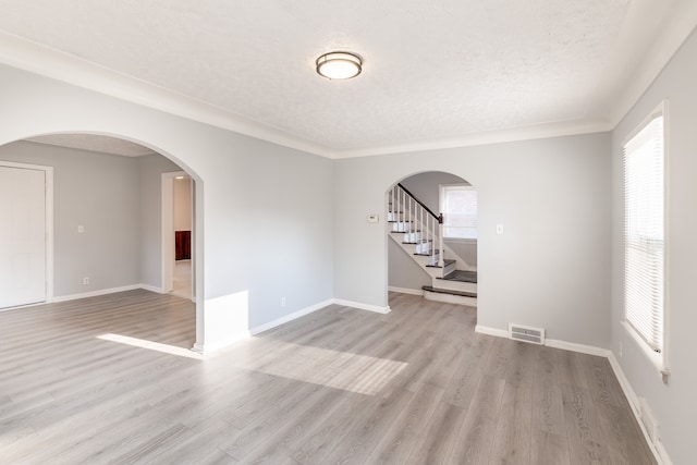 unfurnished room featuring light hardwood / wood-style flooring and a textured ceiling