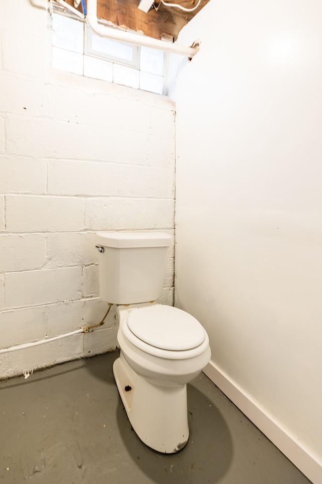 bathroom featuring concrete floors and toilet