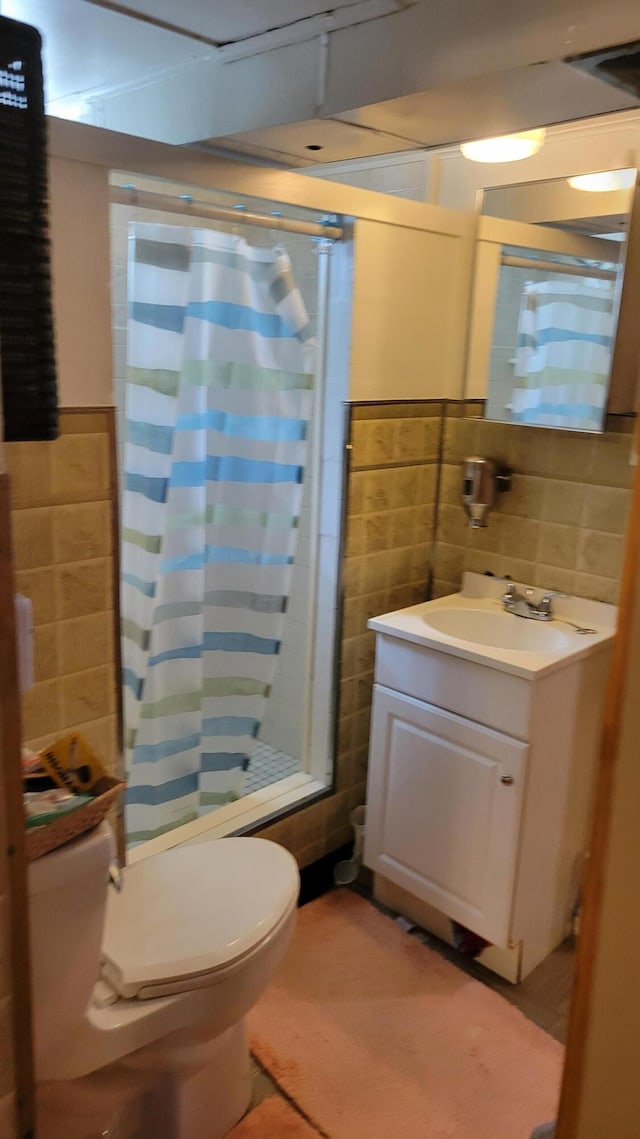 full bathroom with vanity, toilet, tile walls, and shower / tub combo