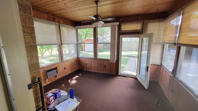 unfurnished sunroom featuring ceiling fan, wood ceiling, and heating unit