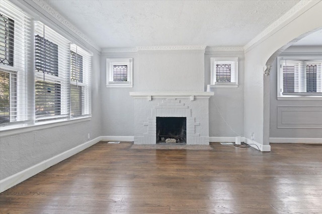 unfurnished living room with a textured ceiling, dark hardwood / wood-style floors, and crown molding