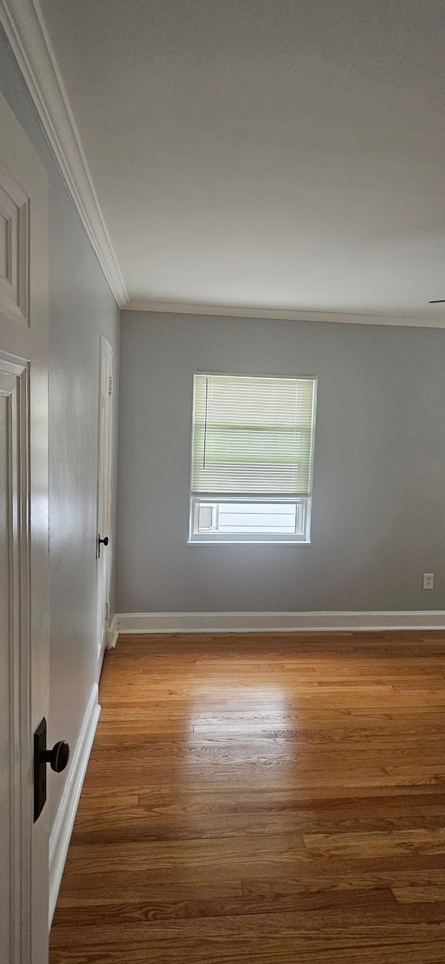 unfurnished room featuring hardwood / wood-style flooring and ornamental molding