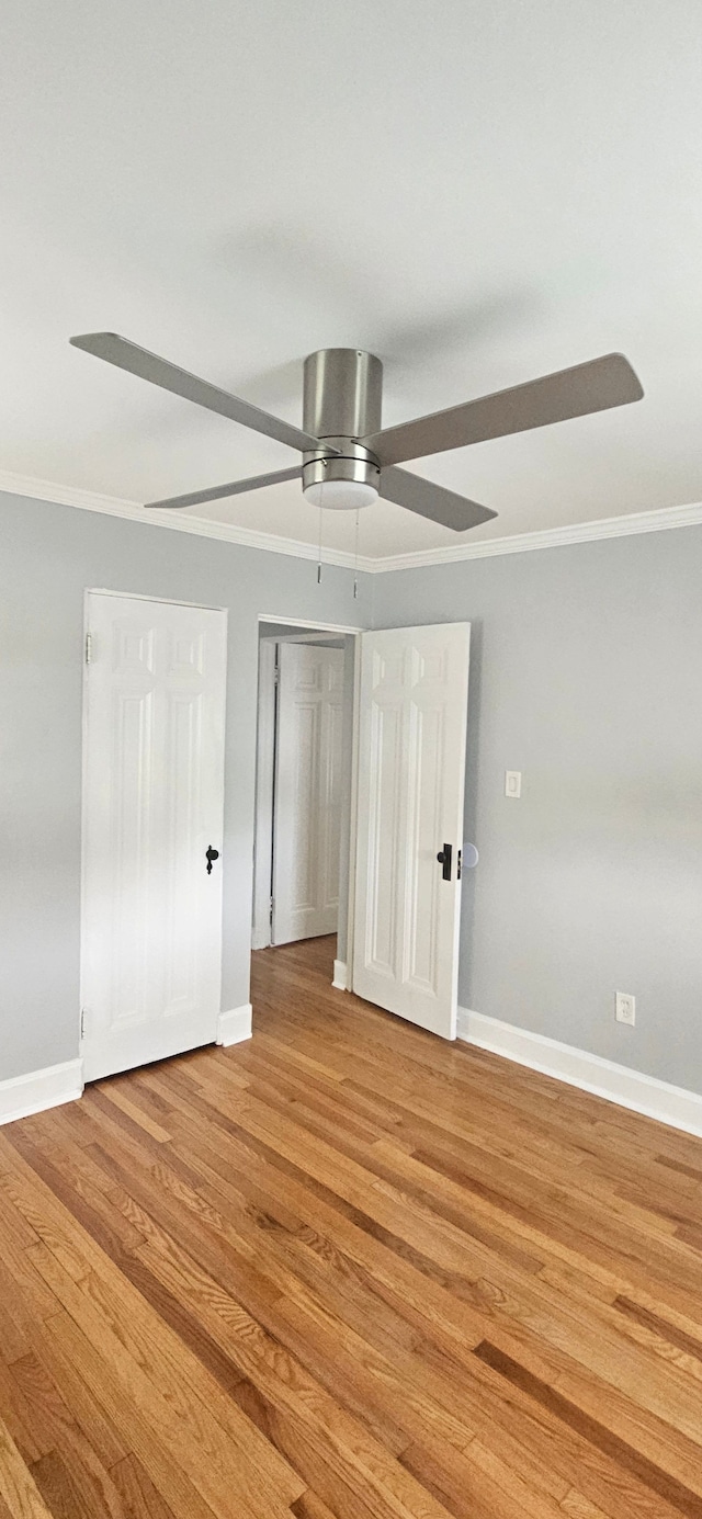 unfurnished bedroom with ceiling fan, light hardwood / wood-style floors, and ornamental molding