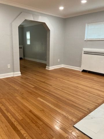 bonus room featuring hardwood / wood-style floors and radiator heating unit