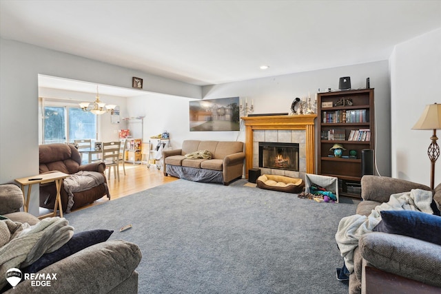 living room with a fireplace, hardwood / wood-style floors, and an inviting chandelier