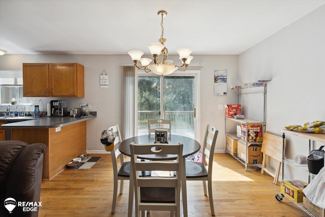 dining area with light hardwood / wood-style flooring, a chandelier, and sink