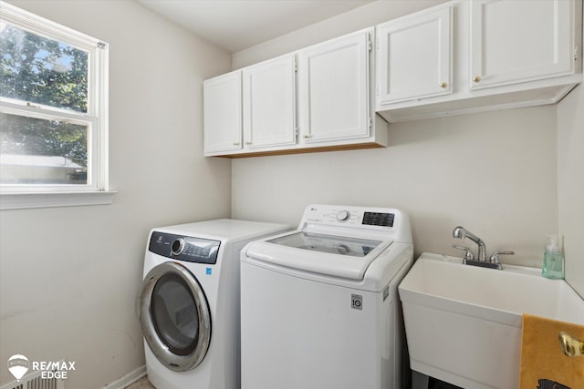 laundry area with separate washer and dryer, sink, and cabinets