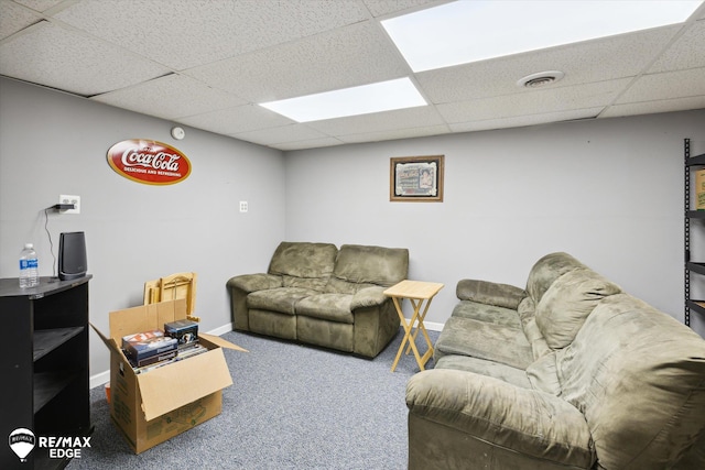 living room with a paneled ceiling and carpet