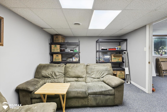 carpeted living room featuring a drop ceiling