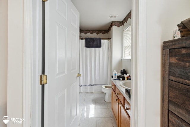 bathroom with tile patterned flooring, vanity, and toilet