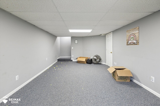 basement with carpet and a paneled ceiling