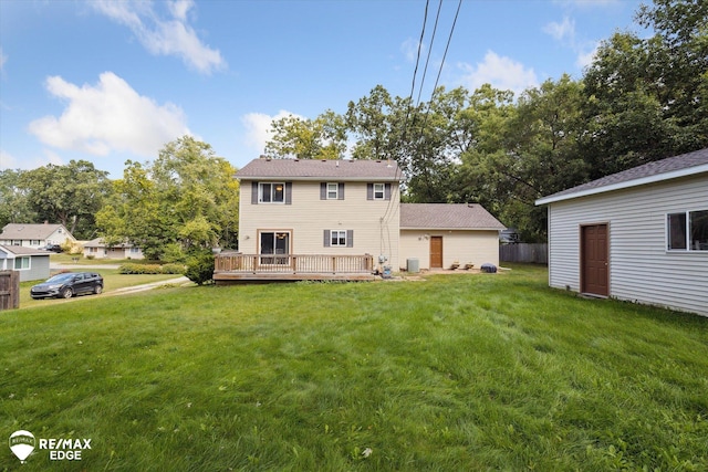 back of house featuring a lawn and a wooden deck