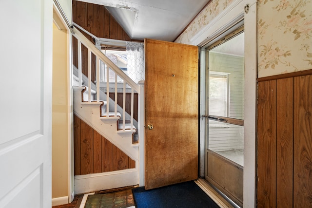 doorway to outside featuring a wealth of natural light and wooden walls