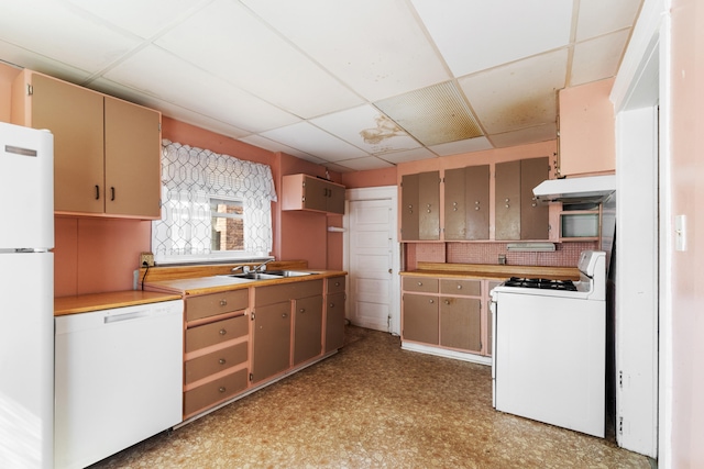 kitchen with a drop ceiling, white appliances, sink, and tasteful backsplash