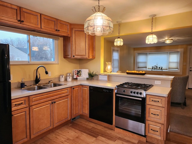 kitchen featuring hanging light fixtures, sink, kitchen peninsula, and black appliances