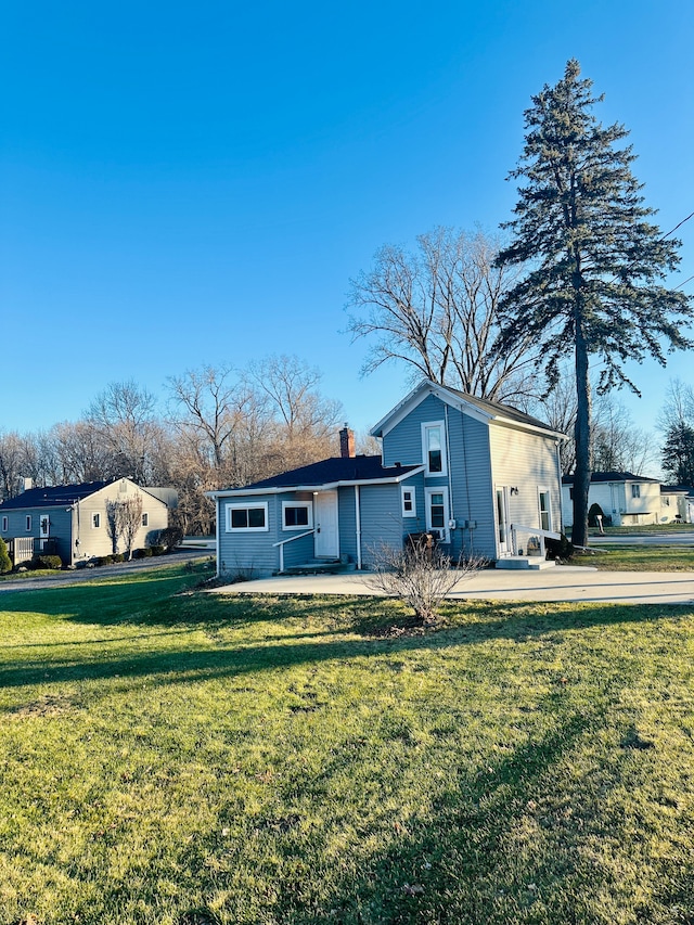 rear view of property with a yard and a patio