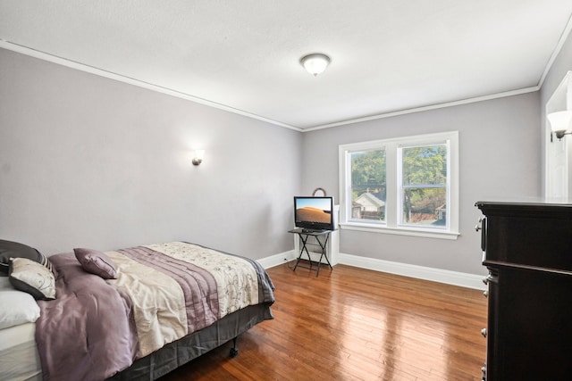 bedroom with hardwood / wood-style flooring and crown molding