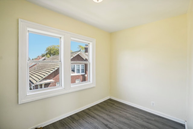 unfurnished room with dark wood-type flooring