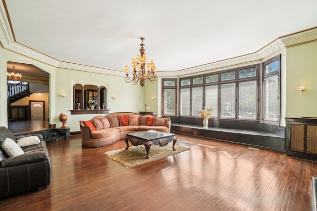 living room with a chandelier, wood-type flooring, and ornamental molding