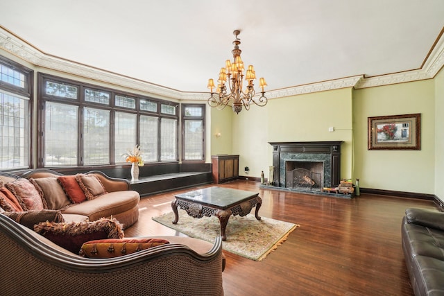 living room featuring hardwood / wood-style floors, a premium fireplace, crown molding, and a chandelier