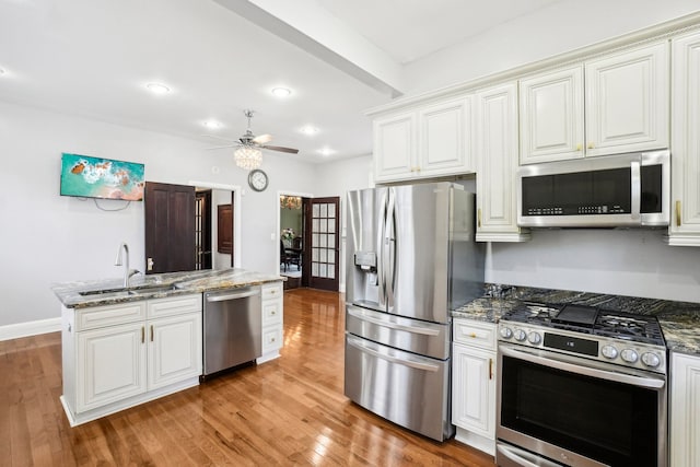 kitchen featuring white cabinets, sink, stainless steel appliances, and light hardwood / wood-style flooring