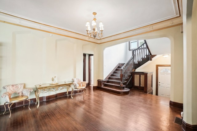 basement with a notable chandelier, wood-type flooring, and ornamental molding