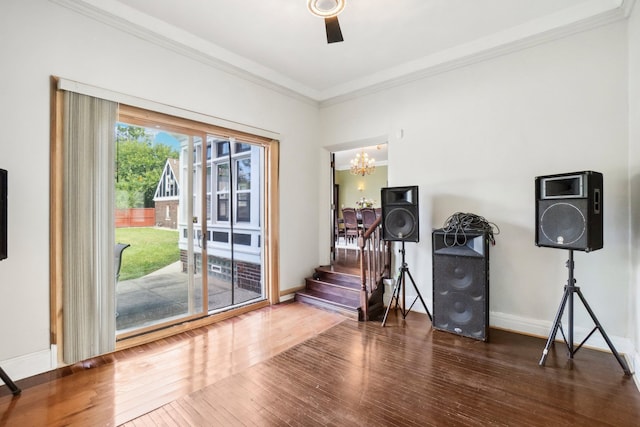 doorway to outside with a chandelier, dark wood-type flooring, and ornamental molding