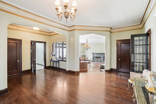 interior space featuring ornamental molding, dark wood-type flooring, and an inviting chandelier