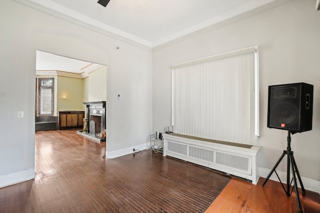 unfurnished room featuring hardwood / wood-style floors, radiator heating unit, and crown molding