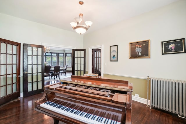 misc room with french doors, dark wood-type flooring, radiator, and a chandelier