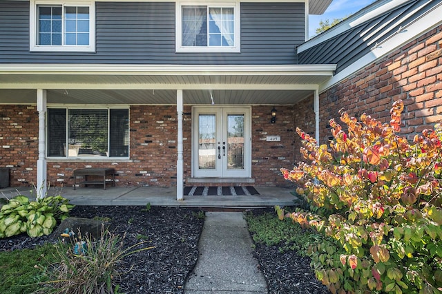 property entrance featuring covered porch and french doors