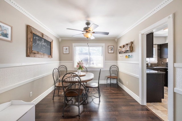 dining space with ceiling fan, crown molding, and dark wood-type flooring