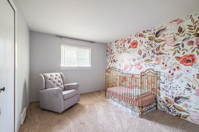 carpeted bedroom featuring a nursery area