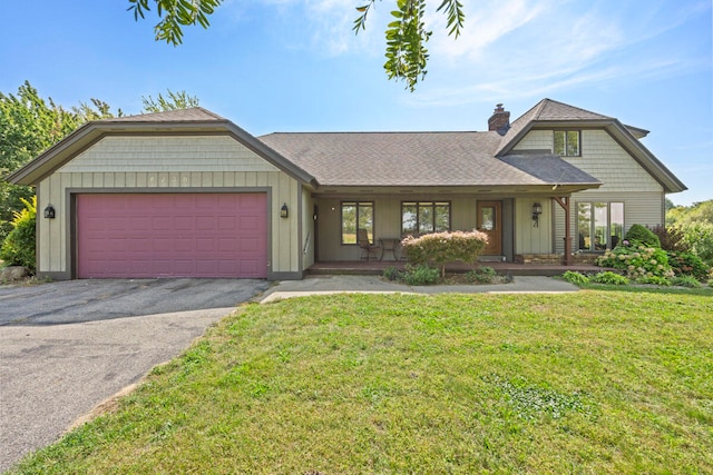 view of front of home with a front yard, a porch, and a garage