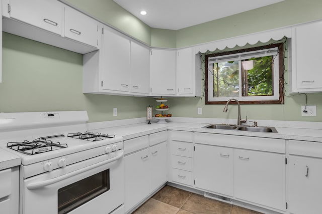 kitchen featuring white cabinets, sink, and gas range gas stove