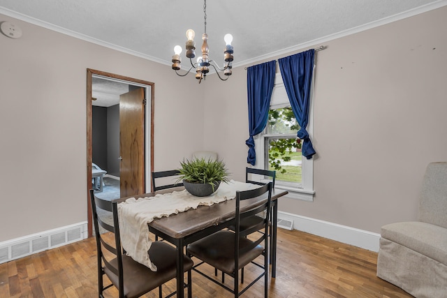 dining room featuring crown molding, a notable chandelier, and hardwood / wood-style flooring