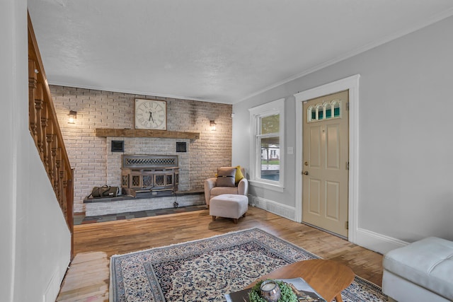 living room with crown molding, brick wall, and light wood-type flooring