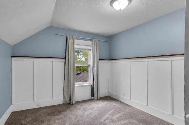 bonus room featuring lofted ceiling, carpet floors, and a textured ceiling