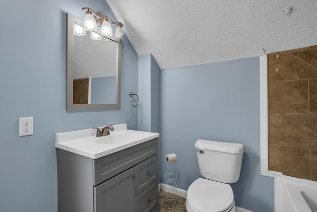 bathroom featuring vanity, toilet, a textured ceiling, and a tub