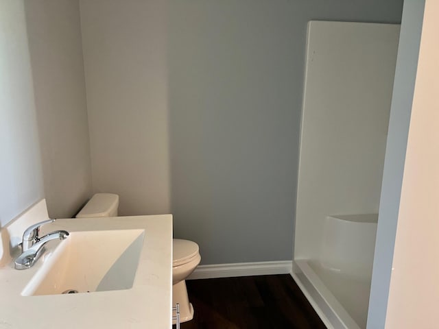 bathroom featuring wood-type flooring, toilet, and sink