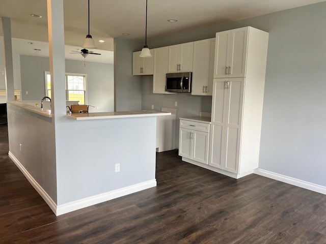 kitchen featuring ceiling fan, white cabinetry, dark wood-type flooring, and decorative light fixtures