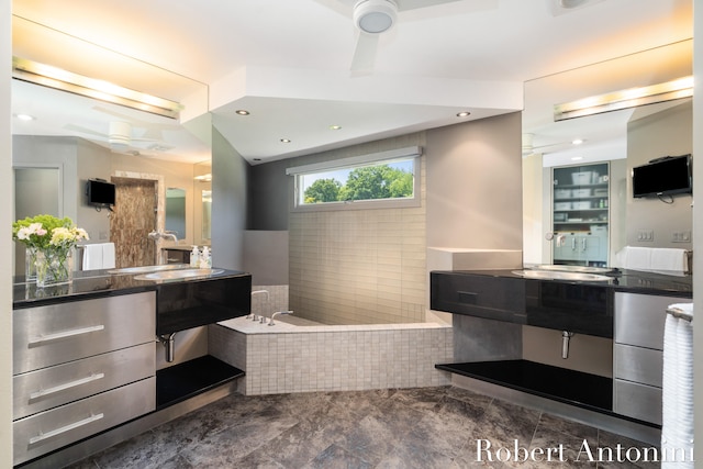 bathroom featuring tiled tub, ceiling fan, and vanity