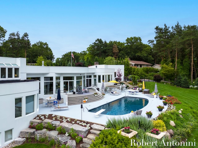 view of swimming pool with a diving board and a patio area