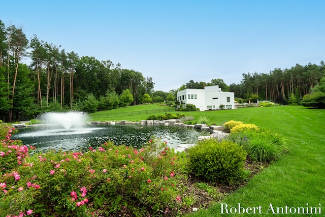 surrounding community with a yard and a water view