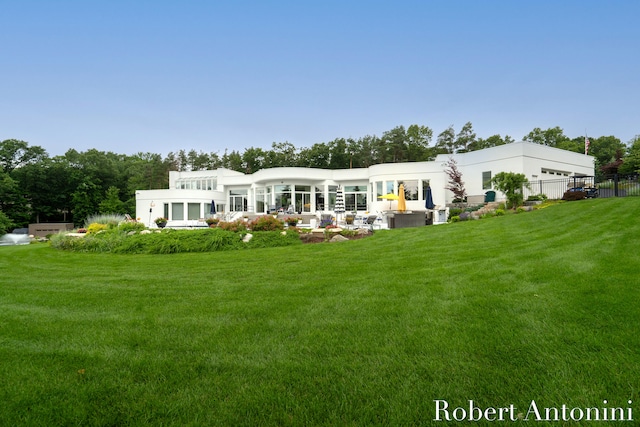 rear view of house featuring a yard