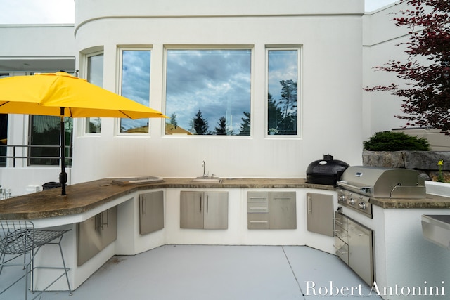 view of patio with grilling area, sink, and exterior kitchen