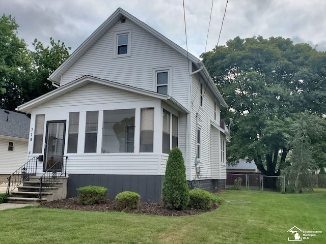 view of front of home featuring a front lawn and a sunroom