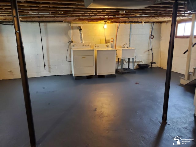 basement featuring independent washer and dryer and sink